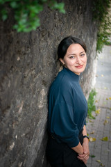 Young beatifull arabic girl with brown eyes is leaned back to the wall. Person with smart elegant clothes. Background image.