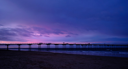  Saltburn pier in winter with dramatic sky in evening, Saltburn is a seaside town located on the northeast coast of the UK, Perspective of wooden bridge to the sea with reflection of light under