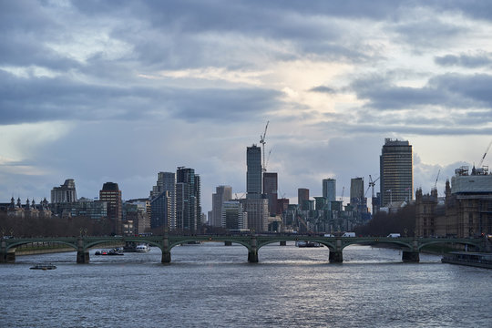 Cityscape or panoramatic Picture of London, capitol of Great Britain, taken in cloudy evening in blue hour shown Westminster bridge over the river Thames and modern architecture with skyscrapers.