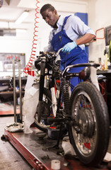Fototapeta na wymiar Service engineer repairs a motorcycle steering wheel in a motorcycle service