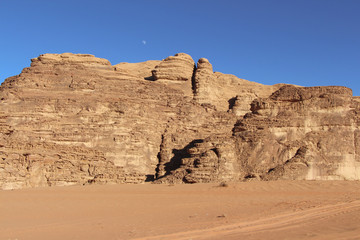 Fototapeta na wymiar Textured sand mountains in Wadi Rum desert in Jordan. Clear blue sky. Theme of travel and safari in Jordan.