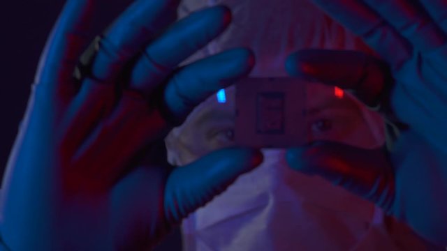 Scientist completed a scientific experiment in electronics. Silicon electronic chip in the hands of a researcher in lablaboratory. Engineer testing experimental innovation in cyber technology industry