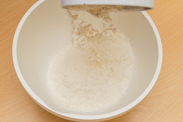Cooking dough in a white plastic bowl at home