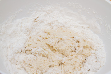 Cooking dough in a white plastic bowl at home