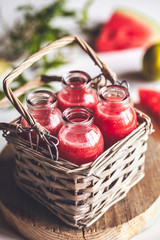 Watermelon juice in jars with a basket with mint leaves and lime citrus