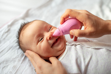 mother using baby nasal aspirator mucus nose suction
