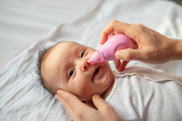 mother using baby nasal aspirator mucus nose suction