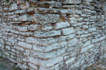 Corner of an old stone wall. Flat gray stones have damage over time. Background. Texture.