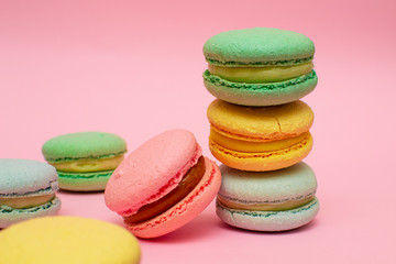 Fototapeta na wymiar Fresh Bright Colored Macarons, or Macaroons on a Pink Background