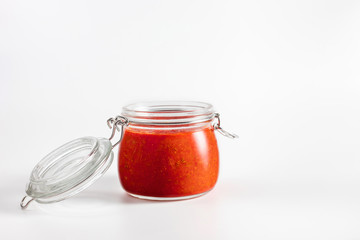 Hot chili pepper sauce paste harissa. Adjika. Traditional Tunisia, Georgian and Arabic cuisine. Homemade rose harissa in a glass jar.