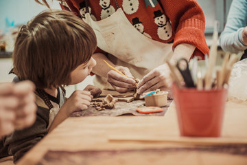 The child is engaged in a pottery school, sculpts a clay product