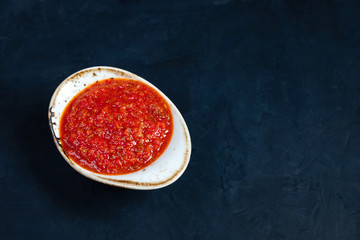 Hot chili pepper sauce paste harissa. Adjika. Traditional Tunisia, Georgian and Arabic cuisine. Homemade rose harissa in a bowl.