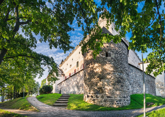 Fototapeta na wymiar Medieval Towers of Zvolen Castle in Zvolen town, Slovakia. Panoramic summer view of Castle from park with beautiful path winding around the castle