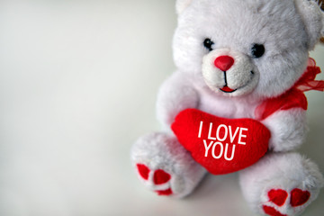 White teddy bear holds red heart with text I Love You