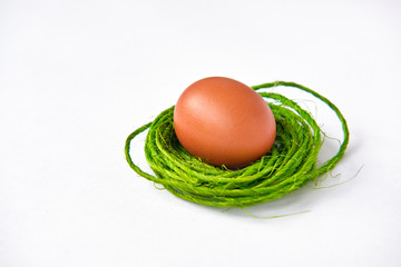Easter egg lies in a green nest from twine
