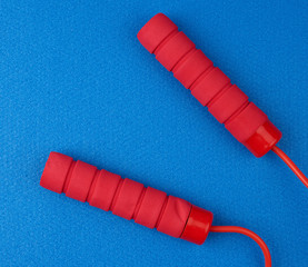 neoprene handles red rope lying on a blue neoprene sports mat