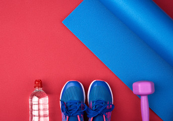 pair of blue training sneakers with laces, bottle of water