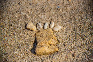 Foot pebbles on the sand