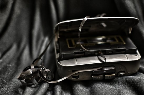 Close-Up Of Damaged Personal Cassette Player On Fabric