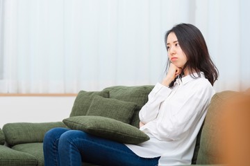 Obraz premium リビングのソファーに座る女性