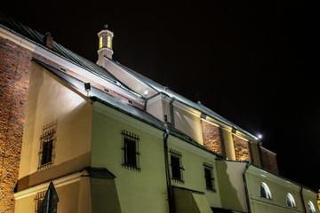 Fototapeta na wymiar Old catholic church against the black sky photographed at night