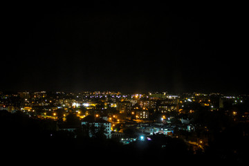View of the night city in the street lights and the light in the windows of the houses. Night city landscape.