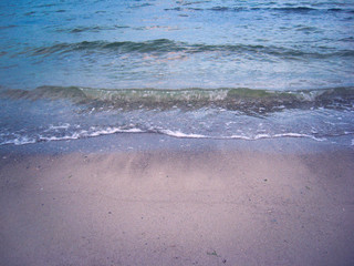 Fototapeta na wymiar The soft sea waves gently roll on the sandy beach. Beautiful picture of dawn on the seashore.