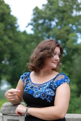 Naklejka premium portrait of young woman in a park in a blouse of Irish lace
