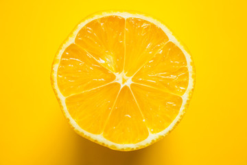 Fototapeta na wymiar Half of a juicy ripe lemon in close-up on a bright yellow background with space for copying