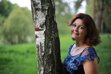 portrait of young woman in park in a blouse of Irish lace