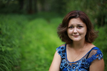 Naklejka premium portrait of young woman in park in a blouse of Irish lace