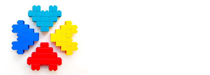 World Autism Awareness day. Multicolored hearts made toy blocks on white background. Mental health care concept with copyspace. Banner