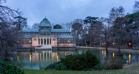 Fototapeta na wymiar Views of the lagoon and the Crystal Palace in the Retiro Park in Madrid on a cloudy day, travel concept.