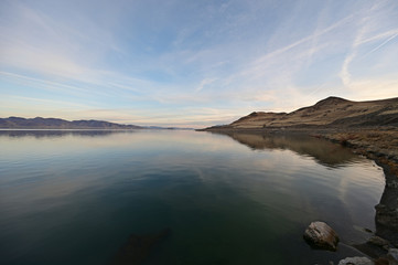Rock formations and reflections of Pyramid Lake, Nevada on clear tranquil winter afternoon.