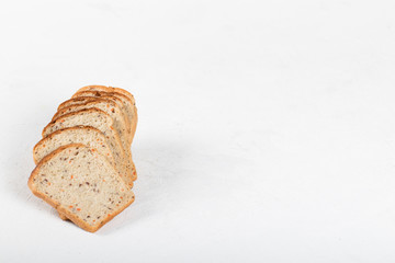 Whole grain fitness bread with dried carrots and flax, pumpkin, and sunflower seeds, sliced on a light background