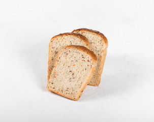 Whole grain fitness bread with dried carrots and flax, pumpkin, and sunflower seeds, sliced on a light background