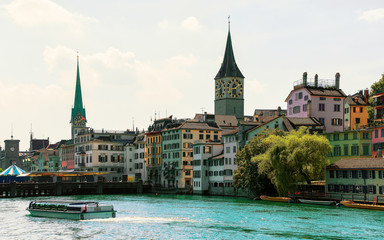 River cruiser at Limmat quay and Saint Peter Church and Fraumunster Church in the city center of...