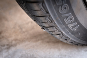 Close-up nail or screw stick on the car tire, the most problem of flat tire