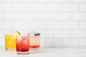 cocktail drinks on white tile backdrop 