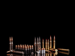 Bullet isolated on black background with reflexion. Rifle bullets close-up on black back....