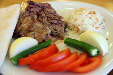 Turkish Doner Kebab with rice and vegetables on the dinner plate