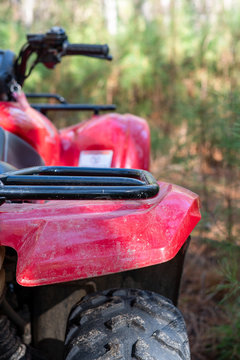 Red four-wheeler off road in the forest, soft focused woods background with copy space ~DIRT~