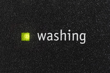 Macro close up photograph of washing indicator light on dishwasher machine.  