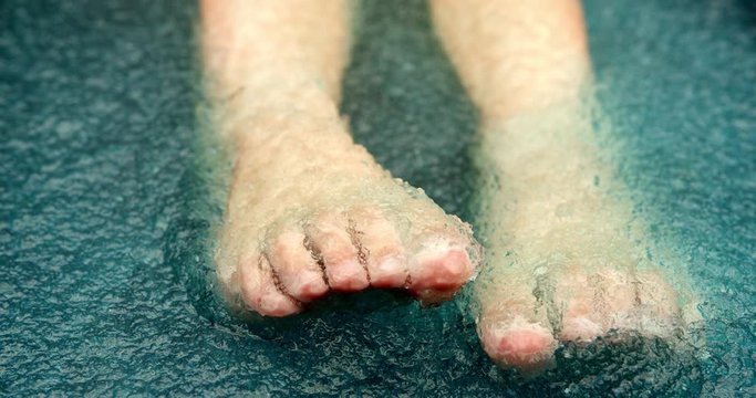 child feet playful in blue slushy slime