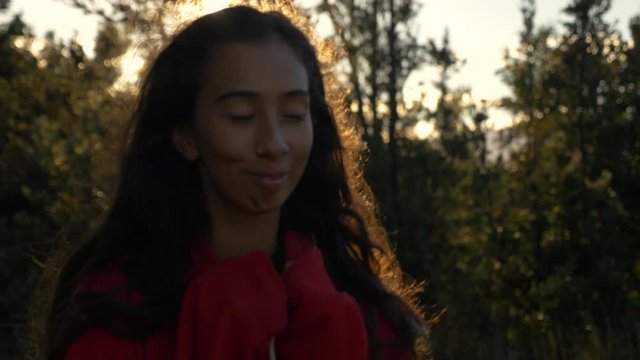 smiling girls looks into camera at golden hour in Hawaiian forest