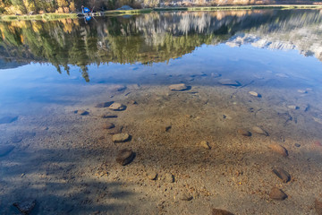 lake bed through transpatent water with reflections and shadows