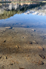 lake bed through transpatent water with reflections and shadows