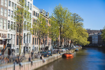 Fototapeta na wymiar View of Amsterdam street in the historical center, with canal houses in the capital city of Amsterdam, North Holland, Netherlands, summer sunny day