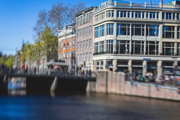 View of Amsterdam street in the historical center, with canal houses in the capital city of Amsterdam, North Holland, Netherlands, summer sunny day