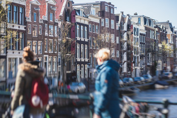 Obraz premium View of Amsterdam street in the historical center, with canal houses in the capital city of Amsterdam, North Holland, Netherlands, summer sunny day